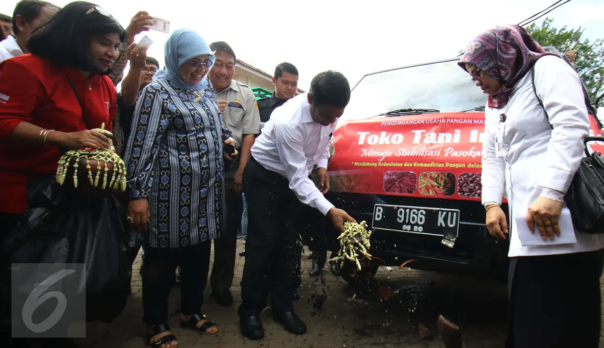 Menteri Pertanian Amran Sulaiman memecah kendi pada kendaraan Toko Tani Indonesia di TTI Center, Jakarta Selatan, Senin (6/2). Kementan melakukan pengiriman perdana komoditas pangan strategis ke 22 TTI yang tersebar di Jakarta. (Liputan6.com/Helmi Afandi)