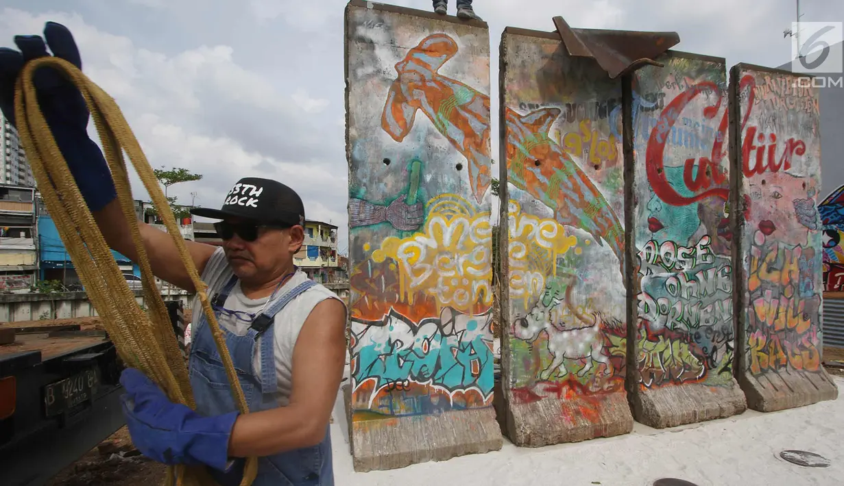  Seniman Teguh Ostenrik saat memasang bongkahan Tembok Berlin di RPTRA Kalijodo, Jakarta, Selasa (26/9). Empat segmen pecahan Tembok Berlin dan 14 "Patung Menembus Batas" untuk memperindah bekas lokalisasi Kalijodo. (Liputan6.com/Immanuel Antonius)