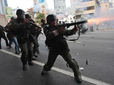 Petugas menembakan gas air mata ke arah demonstran di Caracas, Venezuela, (6/4). Bentrokan dipicu oleh keputusan kontroversial Mahkamah Agung untuk membubarkan parlemen Venezuela yang mayoritas kelompok oposisi. (AP Photo / Ariana Cubillos)