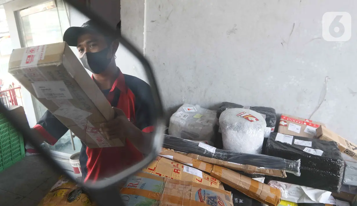 Kurir menaikkan paket untuk dikirim ke atas motor listrik di salah satu gerai ekspedisi jasa di kawasan Jakarta, Senin (5/9/2022). Selain untuk mengikuti anjuran pemerintah, penggunaan motor listrik pada kurir di perusahaan ekspedisi jasa tersebut bertujuan untuk menekan biaya operasional di tengah kenaikan harga bahan bakar minyak (BBM). (Liputan6.com/Herman Zakharia)