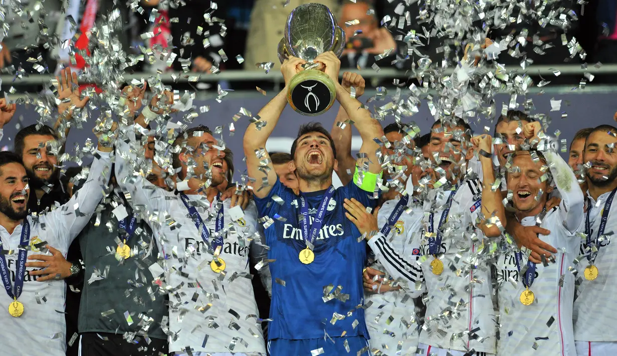 Kiper Real Madrid Iker Casillas mengangkat trofi Piala Super UEFA setelah mengalahkan Sevilla di Stadion Cardiff City di Cardiff, Wales selatan pada 12 Agustus 2014. (AFP/GLYN KIRK)