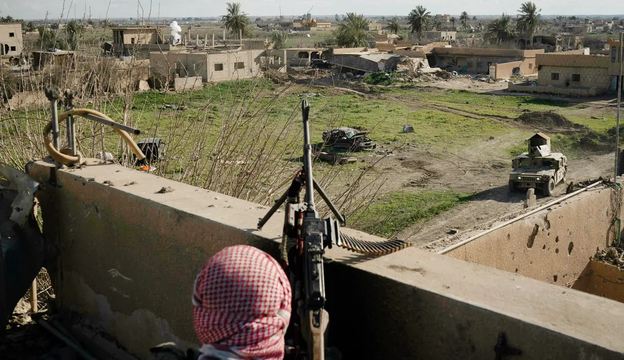 Anggota Syrian Democratic Forces (SDF) mengintai militan ISIS dari sebuah bangunan di kantong terakhir kekhalifahan di Baghouz, Suriah, Senin (18/2). ISIS dilaporkan kian terkepung. (AP Photo/Felipe Dana)