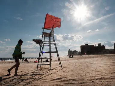 Sebuah kursi penjaga pantai yang kosong berdiri di Coney Island, salah satu tujuan pantai paling populer di wilayah Brooklyn di New York City (29/6/2022). Kota New York menghadapi kekurangan penjaga pantai di kolam renang kota dan pantai tahun ini, memaksa beberapa daerah untuk membatasi waktu berenang. (Spencer Platt/Getty Images/AFP)