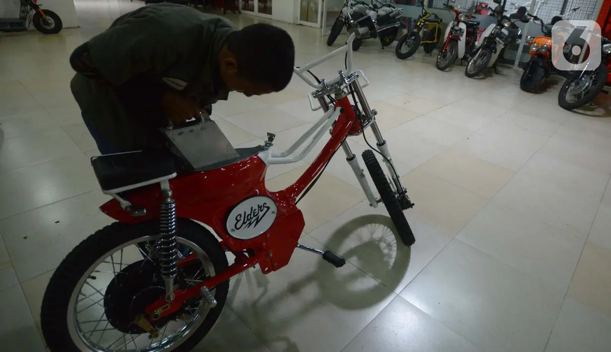 Seorang mekanik memodifikasi motor di Jakarta, Selasa (29/3/2022). Modifikasi motor tersebut merupakan konversi  bahan bakar minyak ke motor listrik. (merdeka.com/Imam Buhori)