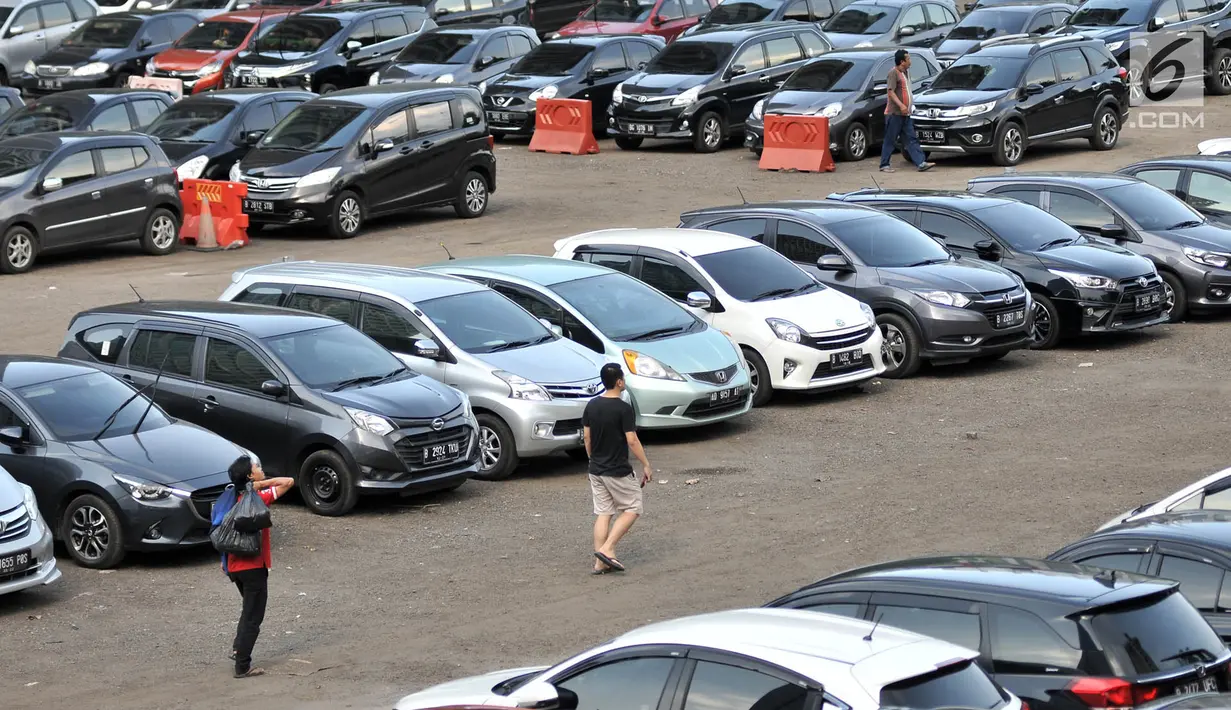 Warga berjalan menuju mobil yang diparkir di Park and Ride kawasan MH Thamrin, Jakarta, Kamis (6/12). Rencana menaikkan tarif parkir ini untuk mendorong masyarakat menggunakan transportasi umum. (Merdeka.com/Iqbal Nugroho)