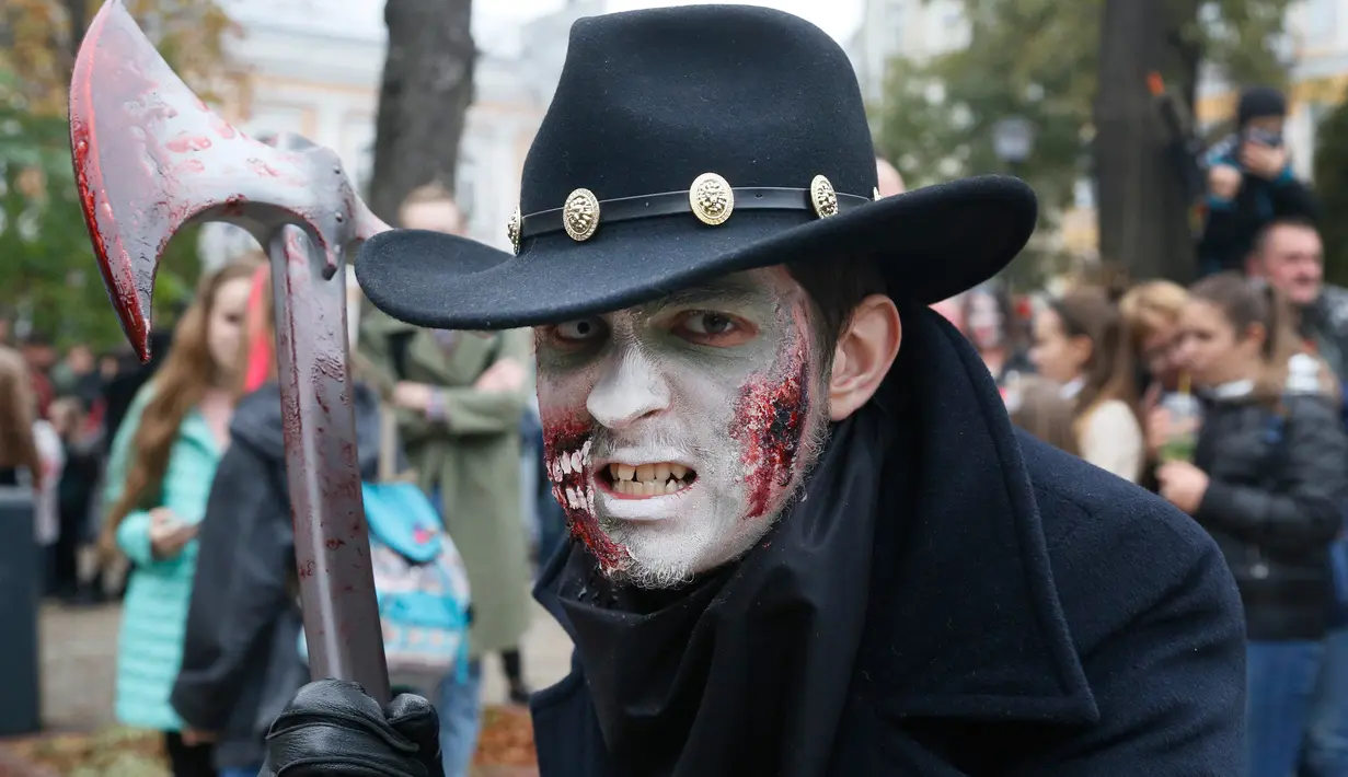 Seorang pria berpose dengan dandanan menyerupai zombie ketika berpartisipasi dalam 'Zombie Walk' di pusat Kota Kiev, Ukraina, 26 Oktober 2019. Menjelang perayaan Halloween pada 31 Oktober mendatang, warga di beberapa belahan dunia sudah mulai melakukan acara bertema horor. (AP/Efrem Lukatsky)