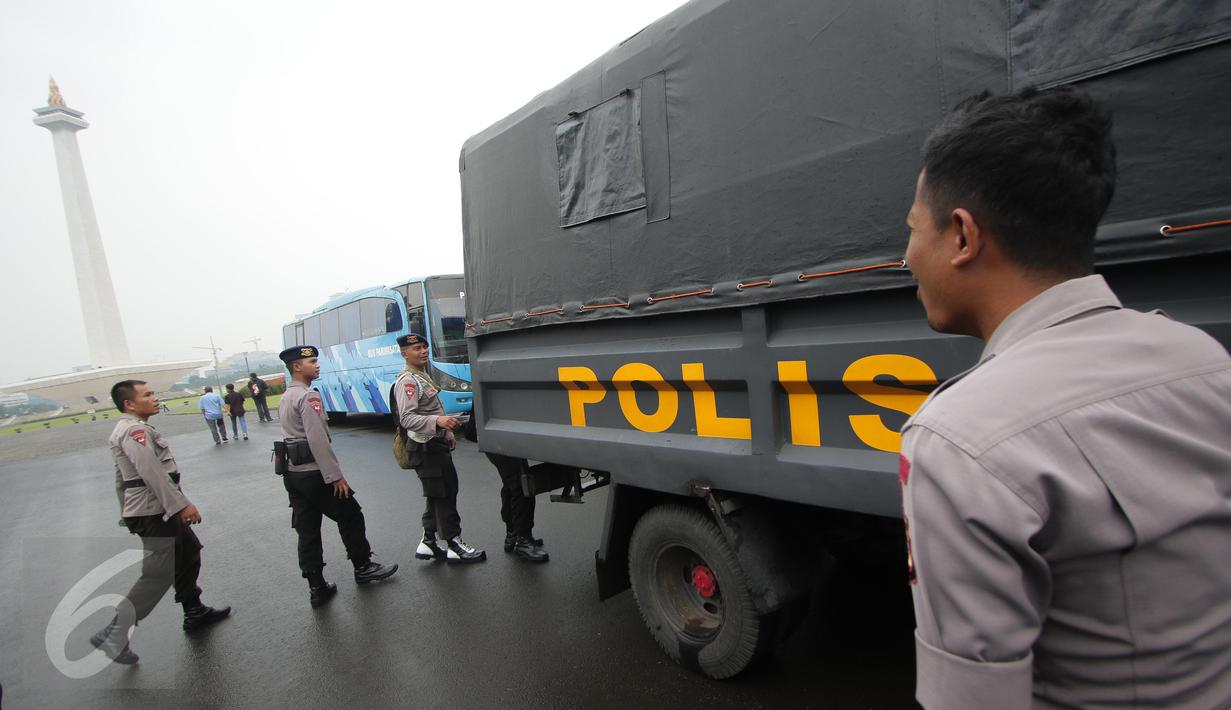 Petugas kepolisian menaiki truk pengangkut saat melakukan pengamanan di kawasan Monas, Jakarta, Selasa (18/4). Polda Metro Jaya dan Kodam Jaya mengerahkan 64.523 personel gabungan untuk mengawal Pilkada DKI 2017 putaran kedua. (Liputan6.com/Faizal Fanani)