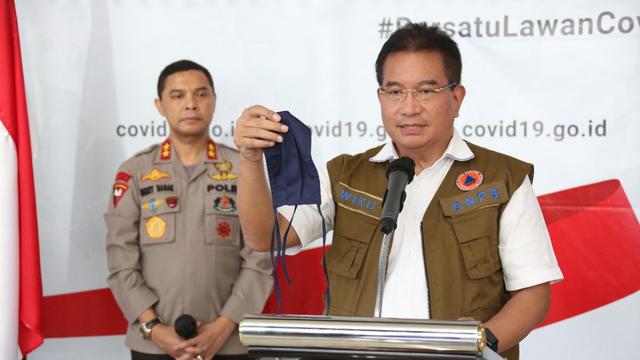 Menggunakan masker tiga lapis/dok. Covid.go.id