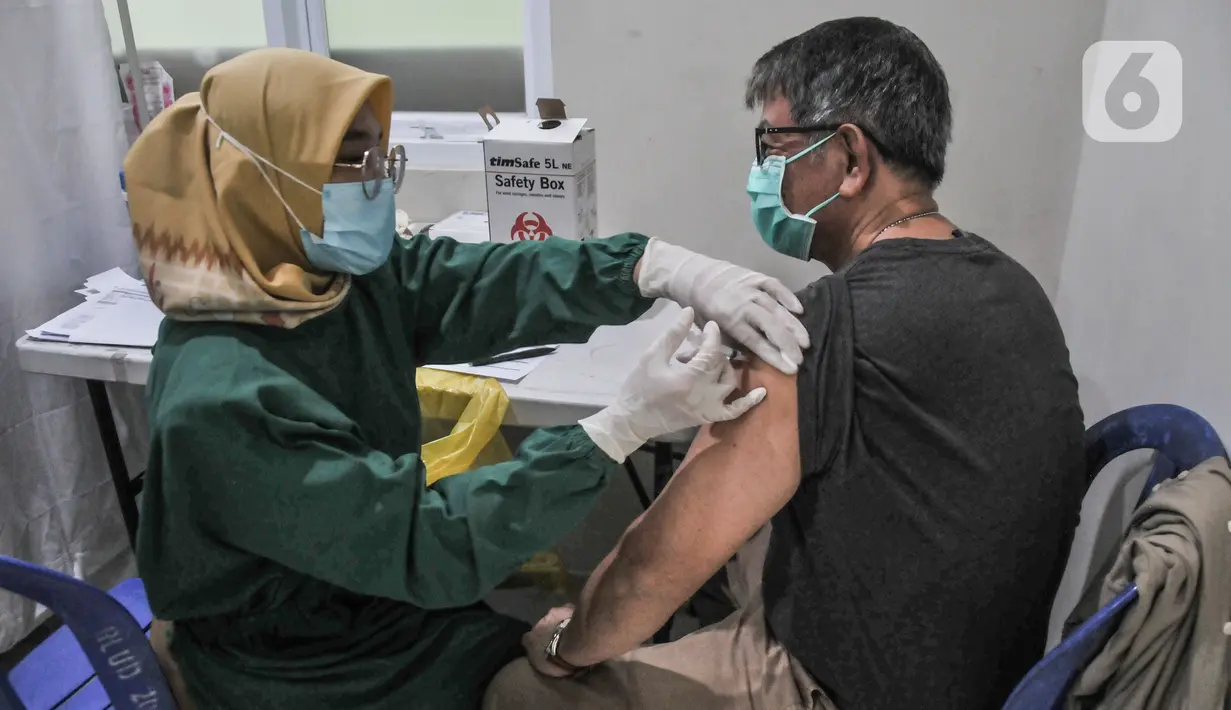 Petugas kesehatan saat menyuntikkan vaksin dosis keempat atau Booster kedua kepada warga di Puskesmas Kecamatan Pulogadung, Jakarta Timur, Selasa (24/1/2023). Vaksin booster kedua diberikan minimal enam bulan setelah masyarakat menerima vaksin booster pertama. Vaksin booster kedua tersedia di fasilitas pelayanan kesehatan dan atau pos pelayanan vaksinasi Covid-19. (merdeka.com/Iqbal S Nugroho)