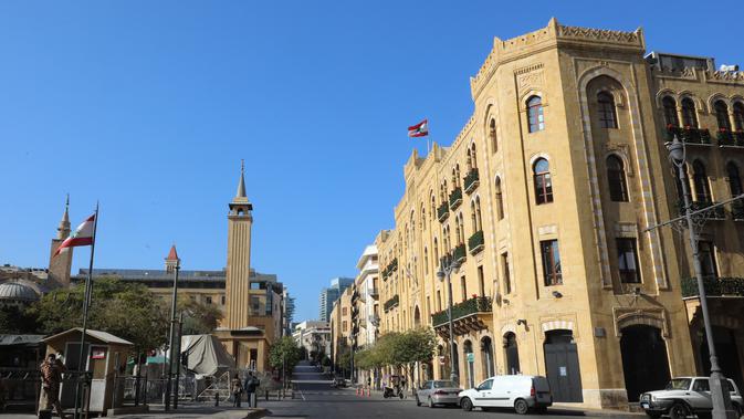 Sebuah jalan utama yang hampir sepi dengan gedung kotamadya (kanan) yang terlihat di pusat Beirut setelah lockdown penuh selama tiga minggu di Lebanon, Minggu (10/1/2021).  Lockdown COVID-19 ini merupakan yang ketiga kalinya di Lebanon sejak pandemi corona tahun 2020. (ANWAR AMRO/AFP)