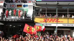 Sebastian Vettel berada di atas podium merayakan kemenangan bersama fans pada balapan pertama musim ini di Grand Prix Formula Satu Australia di Melbourne, (25/3). Vettel memenangi balapan dengan selisih 5,036 detik dari Hamilton. (AP Photo / Rick Rycroft)