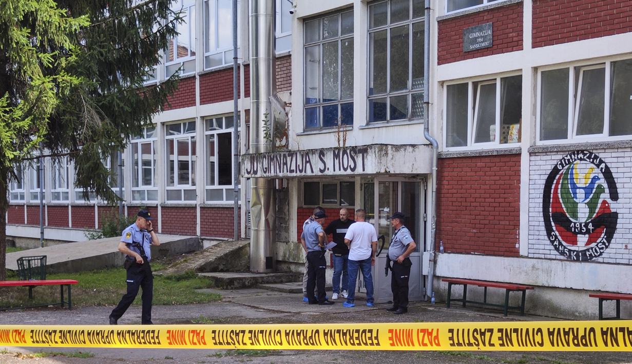 Petugas polisi berdiri di depan gedung sekolah menengah setelah insiden penembakan di Sanski Most, barat laut ibu kota Bosnia, Sarajevo, Rabu (21/8/2024). (AP Photo/Edvin Zulic)
