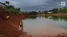 Anak-anak memancing pada bagian proyek pembangunan tol Cinere-Serpong yang berubah menjadi danau sedalam 4 meter di kawasan Cipayung, Tangsel, Banten (17/1). Pembangunan jalan Tol ini sepanjang 10,14 kilometer. (Merdeka.com/Arie Basuki)