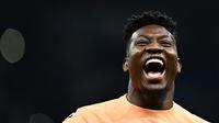 Kiper Inter Milan, Andre Onana merayakan kemenangan atas AC Milan pada laga leg kedua semifinal Liga Champions 2022/2023 di Giuseppe-Meazza Stadium, Milan, 16 Mei 2023. (AFP/Gabriel Bouys)