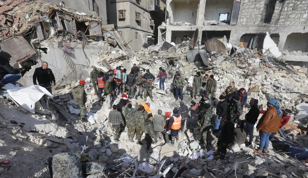 Tim penyelamat Suriah mencari korban dan penyintas yang terjebak di bawah reruntuhan bangunan yang runtuh di Aleppo, Selasa 7 Februari 2023, setelah gempa bumi mematikan yang melanda wilayah tersebut pada hari sebelumnya. Gempa berkekuatan 7,8 SR tersebut terjadi di dekat kota Gaziantep, Turki, menewaskan lebih dari 2.300 orang di Turki dan lebih dari 1.400 orang di negara tetangganya, Suriah. (LOUAI BESHARA/AFP)