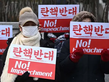 Para pendukung Presiden Korea Selatan yang dimakzulkan, Yoon Suk Yeol, memegang plakat bertuliskan “Tidak Ada Pemakzulan!” di depan Mahkamah Konstitusi di Seoul pada tanggal Selasa 14 Januari 2025. (Jung Yeon-je/AFP)