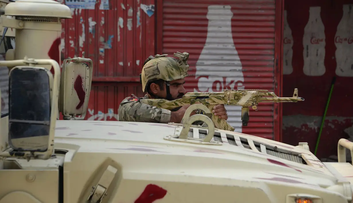 Tentara Afghanistan mengambil posisi saat terjadi serangan di dekat kantor amal Inggris Save the Children di Jalalabad, Afghanistan (24/1). Para penyerang menggunakan granat berpeluncur roket untuk menyerbu kompleks tersebut.(AFP Photo/Noorullah Shirzada)