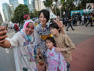 Pengunjung berswafoto dengan warga berpakaian Kimono saat hari pertama acara Jak-Japan Matsuri 2018 di Gelora Bung Karno, Senayan, Jakarta, Sabtu (8/9). Tahun ini, festival mengusung tema Indonesia and Japan Always Together. (Liputan6.com/Faizal Fanani)