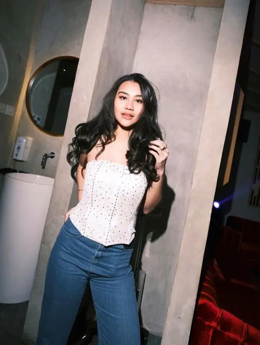 Seperti potret ini, Aaliyah memadukan bandeau top warna putih dengan celana jeans. (Instagram/Aaliyah.massaid).