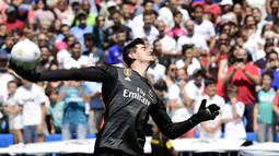 Kiper baru Real Madrid, Thibaut Courtois, melempar bola saat diperkenalkan di Stadion Santiago Bernabeu, Madrid, Kamis (9/8/2018). Pemain berusia 26 tahun pindah setelah empat musim terakhir jadi kiper utama Chelsea. (AFP/Javier Soriano)