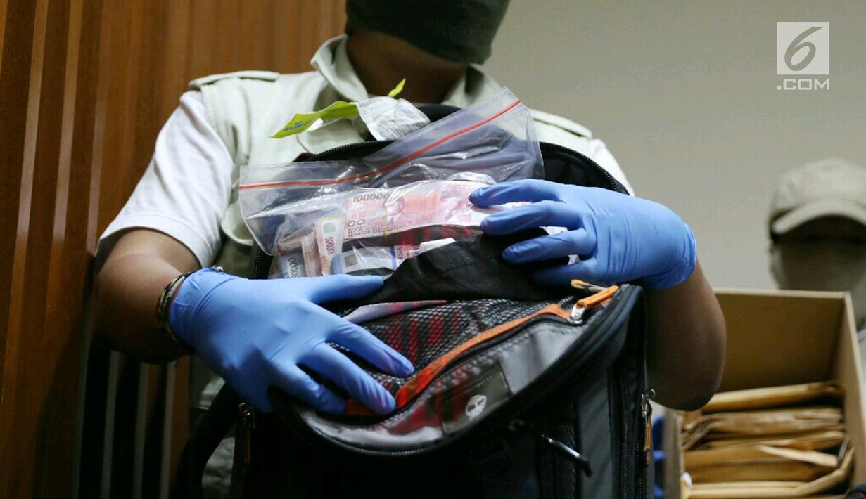 Petugas menunjukkan barang bukti hasil OTT di gedung KPK, Jakarta, Sabtu (27/5).  KPK menyita uang sebanyak Rp40 Juta, Rp1,145 Milyar dan USD 3000 yang diduga sebagai suap terkait pemberian predikat WTP terhadap Kemendes. (Liputan6.com/Angga Yuniar)