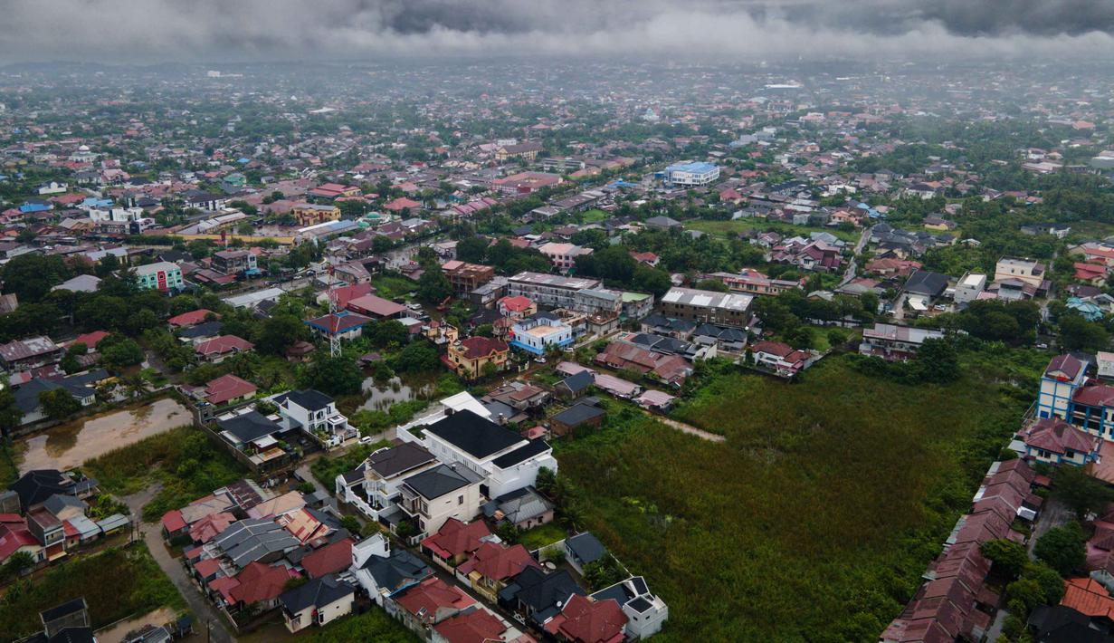 Badan Meteorologi, Klimatologi, dan Geofisika (BMKG) telah mengeluarkan peringatan dini hujan lebat untuk Banda Aceh dan sekitarnya, yang mengindikasikan risiko bencana hidrometeorologi masih tinggi. Tampak foto udara menunjukkan pemandangan umum rumah-rumah penduduk di bawah awan setelah hujan lebat di Darul Imarah, pinggiran Banda Aceh, pada Kamis 27 November 2025. (CHAIDEER MAHYUDDIN/AFP)