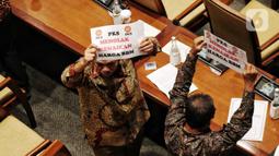 Anggota Fraksi PKS memegang poster bertuliskan “Tolak Kenaikan Harga BBM” saat Rapat Paripurna ke-4 masa persidangan I tahun 2022-2023 di Kompleks Parlemen, Senayan, Jakarta, Selasa (6/9/2022). Dalam rapat paripurna ini beragendakan pengambilan keputusan RUU tentang pertanggungjawaban APBN TA 2021. (Liputan6.com/Angga Yuniar)