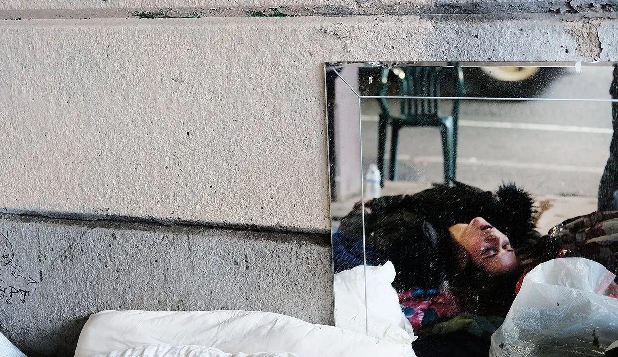 Seorang wanita terkapar usai menggunakan heroin di bawah jembatan yang menjadi pusat penggunaan heroin di Kensington, Philadelphia (24/1). (Spencer Platt/Getty Images/AFP)