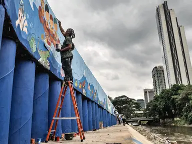 Seniman saat menyelesaikan pembuatan mural di turap Kanal Banjir Barat, Jakarta, Rabu (13/1/2021). Pembuatan mural bertemakan "Kehidupan Sungai" yang dikerjakan oleh seniman dari Komunitas Mural Depok tersebut bertujuan mempercantik lingkungan di sekitar Kali Ciliwung. (merdeka.com/Iqbal S. Nugroho)