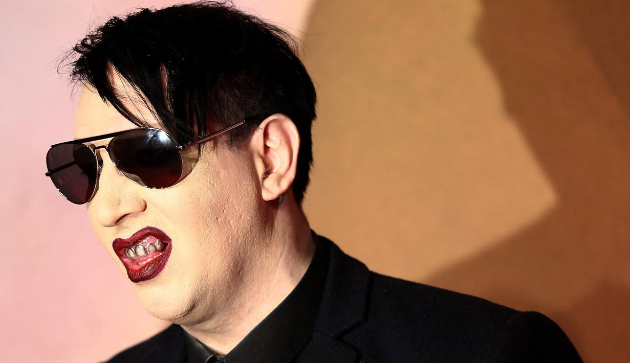 Rocker, Marilyn Manson berpose saat menghidiri di Fashion Awards 2016 di London, Inggris (5/12). Mengenakan Jas dan kacamata hitam Marilyn Manson tampil keren saat menghadiri acara tersebut. (REUTERS/Neil Balai)
