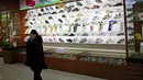 Seorang wanita berdiri di ruang pameran produk di Ryuwon Shoe Factory yang berspesialisasi dalam sepatu olahraga, di Pyongyang, Korea Utara (1/2). (AP Photo/Dita Alangkara)