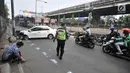 Petugas kepolisian mengurai kemacetan di lokasi kecelakaan taksi menabrak tiang di Jalan Ahmad Yani, Jakarta, Rabu (1/8). (Merdeka.com/Iqbal Nugroho)