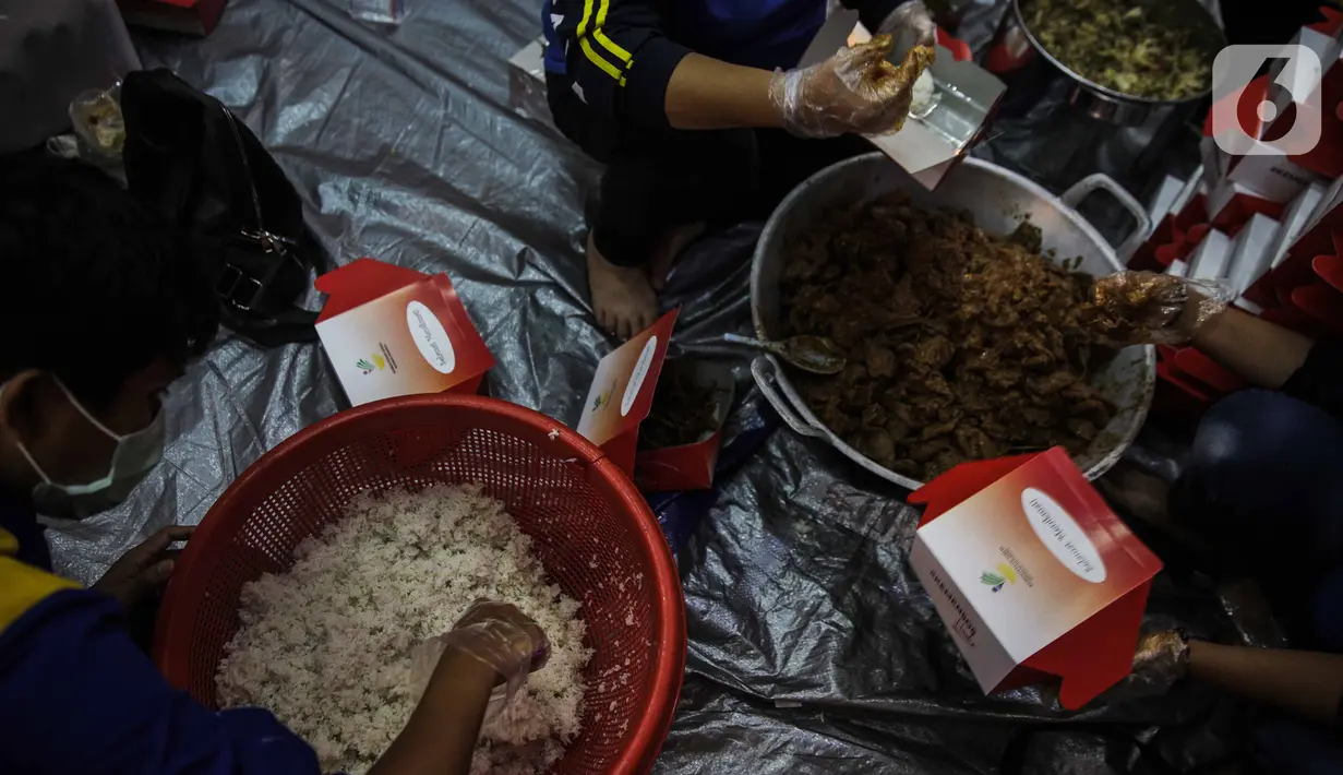 Petugas Taruna Siaga Bencana (Tagana) menyiapkan nasi kotak di Dapur Umum Kementerian Sosial Peduli Dampak Covid-19 di Kompleks Gedung Konvensi TMP Nasional-Utama, Kalibata, Jakarta, Rabu (8/4/2020). Dalam sehari, petugas menyiapkan 5.000 hingga 9.000 paket nasi bungkus. (Liputan6.com/Faizal Fanani)