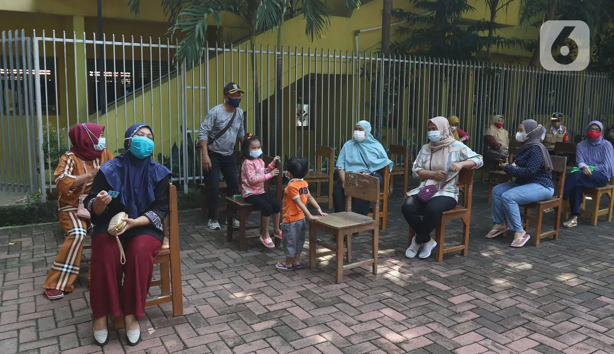 Sejumlah warga menunggu untuk divaksin di MTs As-Syafiiyah, Cilangkap, Jakarta, Kamis (3/6/2021).  Vaksinasi massal bagi warga RT 03/RW 03 Cilangkap, Cipayung, Jakarta Timur menggunakan vaksin produksi AstraZeneca. (Liputan6.com/Herman Zakharia)