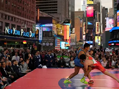 Pegulat dari AS, Zahid Valencia (biru) saat melawan Mojtaba Goleij dari Iran pada kejuaraan gulat Beat the Streets, Times Square, New York (19/5). Pertandingan gulat ini sontak dipadati penonton karena digelar ditengah kota terbuka. (REUTERS/Adrees Latif)