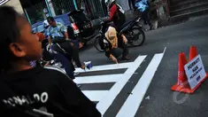 Relawan tergabung dari Koalisi Pejalan Kaki membuat jalur zebra cross di depan Stasiun Sudirman, Jakarta, Jumat (13/3/2015). (Liputan6.com/Faizal Fanani)