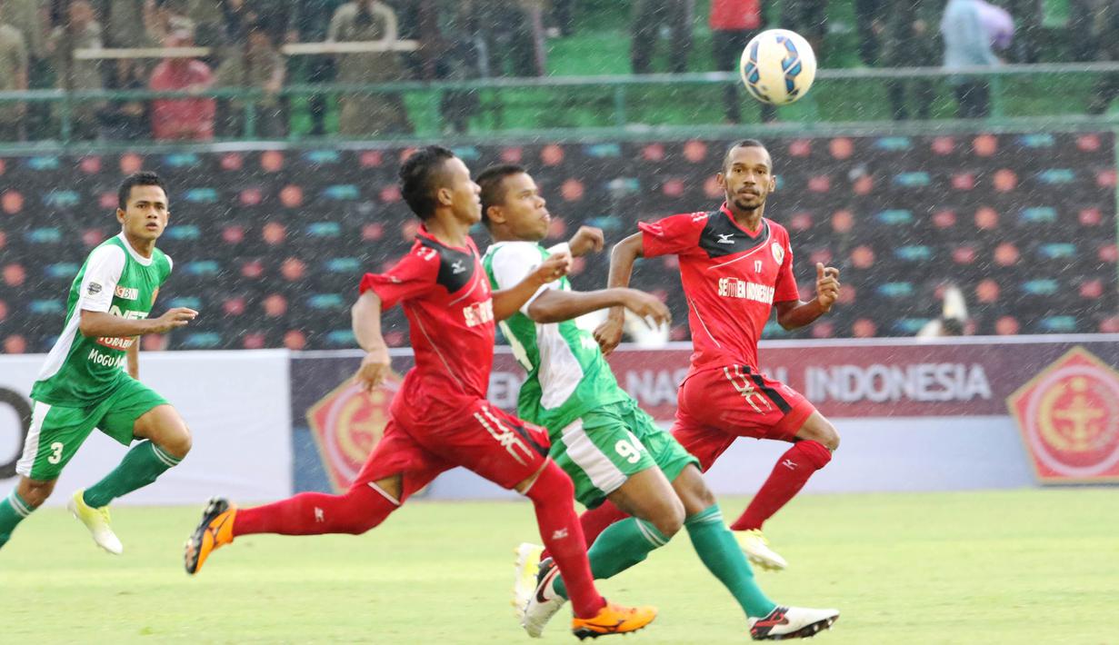 Pemain PS TNI, Manahati Lestusen, berusaha lepas dari kejaran pemain Semen Padang pada laga 8 besar Piala Jenderal Sudirman di Stadion Manahan, Solo, Sabtu (12/12/2015). (Bola.com/Nick Hanoatubun)