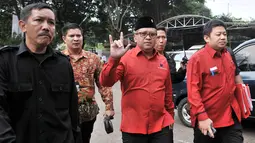 Sekjen PDIP Hasto Kristiyanto (tengah) menyapa awak media saat tiba untuk medaftarkan bakal caleg ke  KPU, Jakarta, Selasa (17/7). Salam metal menjadi ciri khas PDIP karena menggambarkan nomor urut tiga. (Merdeka.com/Iqbal Nugroho)