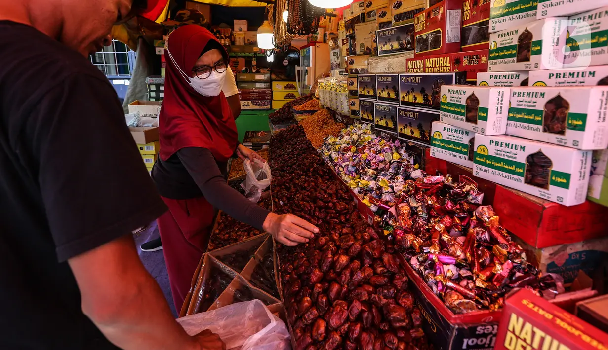 Pedagang kurma melayani pembeli di kawasan Tanah abang, Jakarta, Minggu (3/4/2022). Omset penjualan kebutuhan bulan Ramadhan seperti perlengkapan ibadah dan buah kurma kembali meningkat dibandingkan dua tahun terakhir yang terdampak pandemi COVID-19. (Liputan6.com/Johan Tallo)