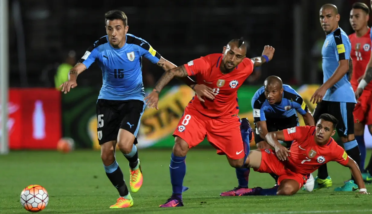 Pemain Cile, Arturo Vidal dan Alexis Sanchez, berebut bola dengan pemain Uruguay pada laga Kualifikasi Piala Dunia 2018 zona CONMEBOL di Stadion Nasional Julio Martinez Pradanos, Santiago, Rabu (16/11/2016) pagi WIB. (AFP/Martin Bernetti)