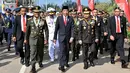 Presiden Joko Widodo (tengah) didampingi Kapolri, Tito Karnavian (kanan) dan Panglima TNI Jenderal Gatot Nurmantyo (kiri) berjalan menuju lokasi upacara HUT ke-72 TNI di Pelabuhan Indah Kiat, Banten (5/10). (Liputan6.com/Pool/Agus Suparto)