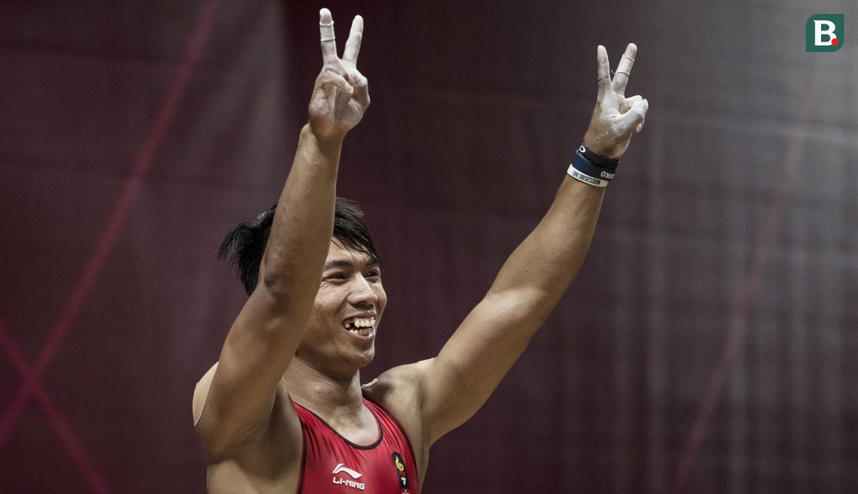 Lifter Indonesia, Deni, menyapa suporter saat berlaga pada Asian Games di JIExpo, Jakarta, Rabu (22/8/2018). Deni memastikan lolos ke final setelah berhasil membukukan poin terbaik dengan total angkatan seberat 318 kg. (Bola.com/Vitalis Yogi Trisna)