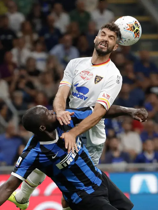 Striker anyar Inter Milan, Romelu Lukaku berebut bola dengan pemain Lecce, Luca Rossettini pada laga pertama Serie A 2019/2020 di Stadio Giuseppe Meazza, Senin (26/8/2019). Inter Milan menang 4-0 saat menjamu tim promosi Lecce. (AP Photo/Luca Bruno)