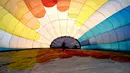 Salah satu tim mempersiapkan balon udara pada festival internasional Sagrantino di kawasan Umbria, Italia, 22 Juli 2018. Puluhan balon udara berkompetisi menghadapi tantangan dalam festival yang memperebutkan piala perak tersebut. (AFP PHOTO/TIZIANA FABI)