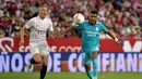 Pemain depan Real Madrid Rodrygo (kanan) berebut bola dengan bek Sevilla Ludwig Augustinsson pada lanjutan Liga Spanyol di stadion Ramon Sanchez Pizjuan, Senin (18/4/2022) dini hari WIB. Real Madrid sukses menaklukkan Sevilla 3-2. (CRISTINA QUICLER / AFP)