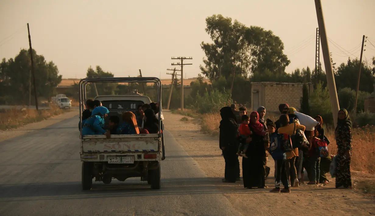 Warga melarikan diri menggunakan mobil saat pasukan Turki memburu milisi Kurdi di Ras al Ayn, Suriah, Rabu (9/10/2019). Turki melancarkan operasi militer memburu milisi Kurdi setelah Amerika Serikat mundur dari wilayah tersebut. (AP Photo/Baderkhan Ahmad)