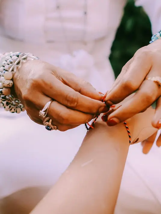 Pemasangan gelang Tri Datu pada lengan Awkarin. (Foto: Instagram/ awkarin)