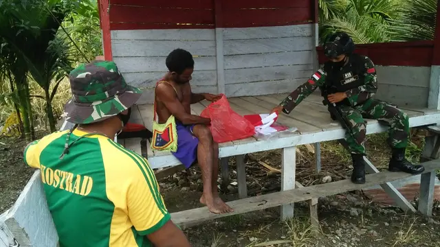 Prajurit TNI mengajak pemuda Yetti mengibarkan Bendera Merah Putih serentak jelang Hari Kemerdekaan. (dok TNI)