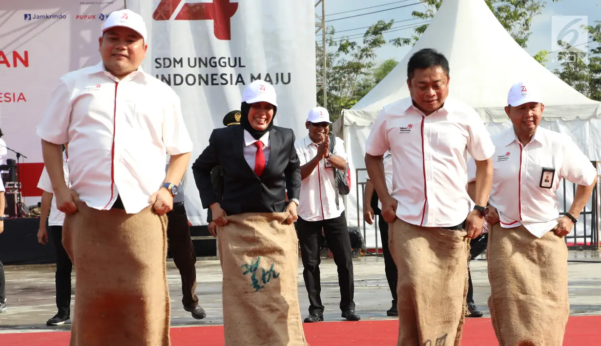 Kabid Kebijakan Tanggung Jawab Sosial Lingkungan Kementerian BUMN Eko Setiawan, Dirjen Potensi Pertahanan Kemenhan Bondan Tiara Sofyan, Dirut Telkom Indonesia Ririek Adriansyah dan Direktur WINS Telkom Edwin Aristiawan mengikuti lomba balap karung di Tarakan, Sabtu (17/8/2019). (Liputan6.com/HO/Ady)