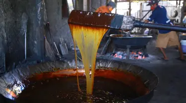 Pekerja mengaduk adonan dodol di pabrik dodol Betawi Mugi Jaya, Cilenggang, Tangerang Selatan, Rabu (13/5/2020). Menjelang hari Raya Idul Fitri permintaan dodol menurun sejak diberlakukan Pembatasan Sosial Berskala Besar (PSBB) selama pandemi Covid-19. (Liputan6.com/Fery Pradolo)